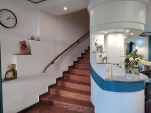 a spiral staircase with a clock on the wall at Queen Lisbeth Street in Keszthely