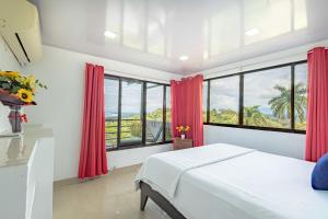 a bedroom with red curtains and a large window at Vista del Pacifico Boutique Hotel in Quepos +108 photos
