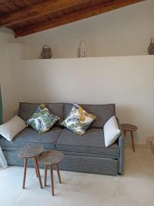 un soggiorno con divano grigio e 2 tavoli di Vita vi a Afionas