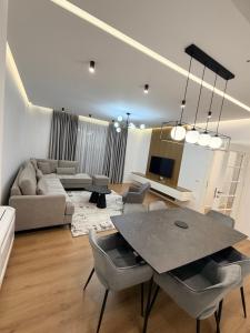 a living room with a table and a couch at LUX Apt Korca in Korçë +5 photos