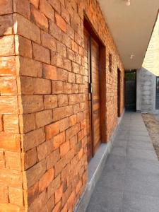eine Backsteinmauer mit einer Tür an der Seite eines Gebäudes in der Unterkunft Pousada Serena Jacumã in Conde + 4 Fotos