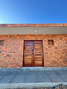 ein Backsteingebäude mit zwei Holztüren darauf in der Unterkunft Pousada Serena Jacumã in Conde