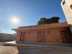 ein Backsteingebäude mit zwei Garagentüren darauf in der Unterkunft Pousada Serena Jacumã in Conde