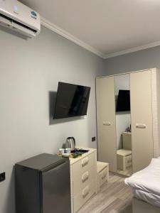 een kamer met een koelkast en een tv aan de muur bij Elite guest house in Pʼarakʼar