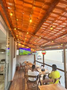 twee mannen aan tafel in een restaurant bij Hotel e Conveniência G3 in Teixeira de Freitas