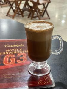 een glas koffie zittend op een tafel bij Hotel e Conveniência G3 in Teixeira de Freitas