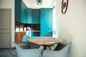 a dining room with a table and blue chairs at Art-House in Uzhhorod