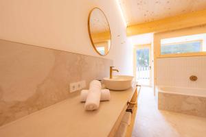 une salle de bain avec un lavabo, une baignoire et un miroir dans l'établissement Hugo und Pepi Appartements, à Mittelberg 41 autres photos