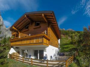 a large wooden house with a balcony on a hill at Chalet Kliben in Leukerbad