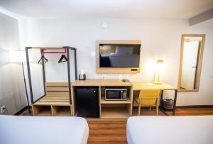 Zimmer mit einem Schreibtisch, einer Mikrowelle und einem TV. in der Unterkunft Park Inn by Radisson in Fargo