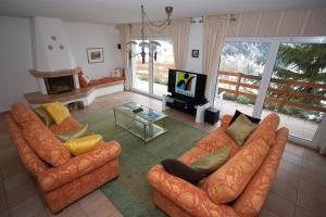 Sala de estar con 2 sofás y TV en Chalet Kliben, en Leukerbad