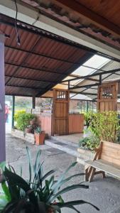 een terras met luifel, een bank en planten bij Cabaña con chimenea Paipa in Paipa