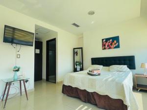 a bedroom with a bed and a flat screen tv at Luxury City Suites in Guayaquil +3 photos