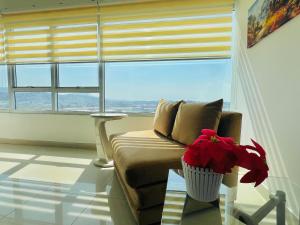 a living room with a couch and a large window at Luxury City Suites in Guayaquil