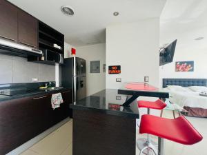 a kitchen with a red stool and a red counter top at Luxury City Suites in Guayaquil