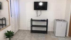 a living room with a television on a wall at אלמוגי אוראל in Eilat