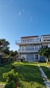 een groot wit gebouw met een tuin ervoor bij Labros Studios in Kastrosikia