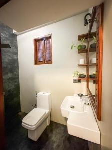 une salle de bain avec des toilettes blanches et un lavabo dans l'établissement Black Lantern, à Matara