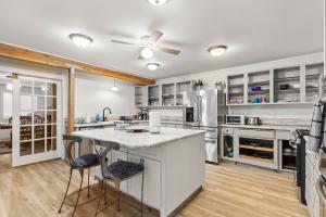 a kitchen with a large island with two bar stools at 4-Bedroom Chateau in Southern Washington- Luxurious Retreat with Pond & Creek in Amboy