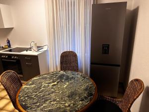 a kitchen with a table and chairs and a kitchen with a refrigerator at Dortmund Brackel Wohnung in Dortmund