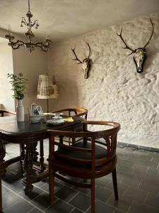 een eetkamer met een tafel en een paar geweien aan de muur bij House Kellisch 1822 in Steffeln