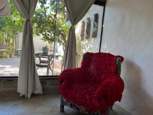a red chair sitting in a room with a window at Oca House in Búzios