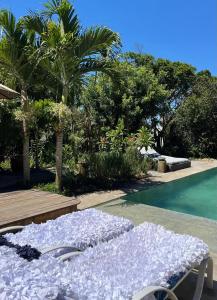 a bed sitting next to a swimming pool at Oca House in Búzios