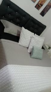 een bed met witte kussens erop bij Hotel Gayra in Antofagasta