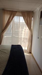 een slaapkamer met een raam en een bed ervoor bij Hotel Gayra in Antofagasta