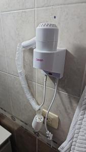 een witte haardroger op de muur van een badkamer bij Hotel Gayra in Antofagasta