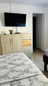 a bedroom with a bed and a flat screen tv at Posada Kotnat in San Andrés