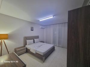 een slaapkamer met een bed en een tafel erin bij chez-moi sfax in Sfax +4 foto's