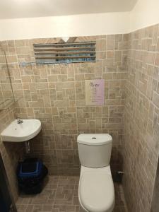 a bathroom with a toilet and a sink at El Nido Cabugao Loudge in El Nido