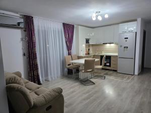 een keuken en woonkamer met een tafel en stoelen bij Mountain View Apartment in Zărneşti