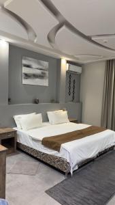 a bedroom with a large bed with white sheets at شاليه ريفالا الفاخر in Abha