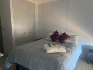 a bed with purple and white pillows on it at Concón Apartment in Concón