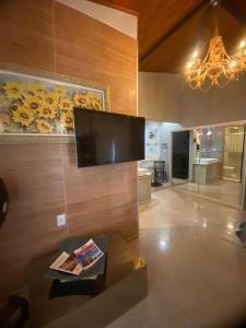 een woonkamer met een flatscreen-tv aan de muur bij Pousada Hibiscos in Serra do Cipo