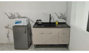 a kitchen with a sink and a microwave at Ruma in Bella Unión