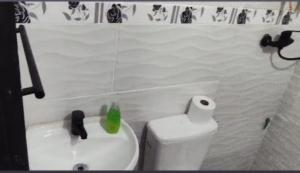 a bathroom with a white toilet and a sink at Ruma in Bella Unión