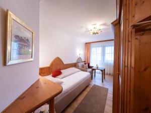 a bedroom with a bed and a table in a room at Hotel Garni Castel B&B in Ischgl