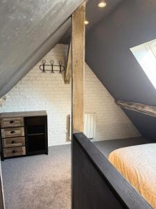 una camera mansardata con letto e camino di Au cœur de pont a Pont-Sainte-Maxence