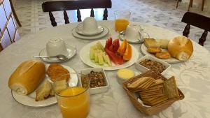 a table with plates of food and glasses of orange juice at Pousada Pineiro in Paraty