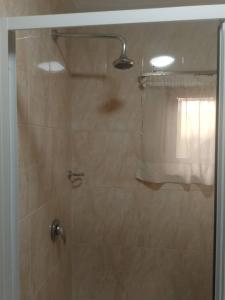 une douche avec une porte vitrée et une fenêtre dans l'établissement Beach Road, à Sékondi