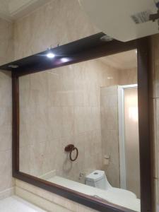 un miroir dans une salle de bain avec baignoire et toilettes dans l'établissement Beach Road, à Sékondi