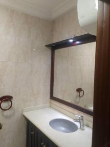 une salle de bains avec un lavabo et un miroir dans l'établissement Beach Road, à Sékondi