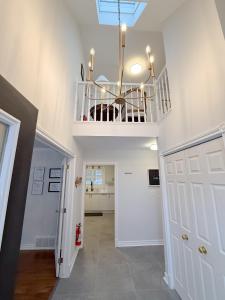 een hal met een trap met een kroonluchter bij The Promenade Cottage License # 002-2023 in Niagara on the Lake