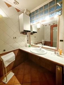 een badkamer met een wastafel en een spiegel bij CASA VACANZA Emma in Monfalcone