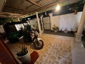 a motorcycle parked in a garage with plants at lakshi's place in Ambalangoda