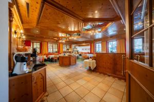 a large kitchen with wooden ceilings and a large room at Hotel Garni Castel B&B in Ischgl