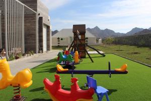 een speeltuin met kleurrijke plastic dieren op het gras bij Masfout Mountains View in Sinādil